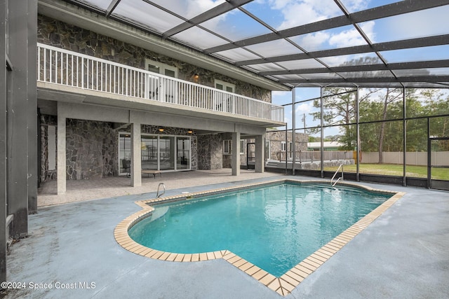 view of swimming pool featuring a patio and glass enclosure