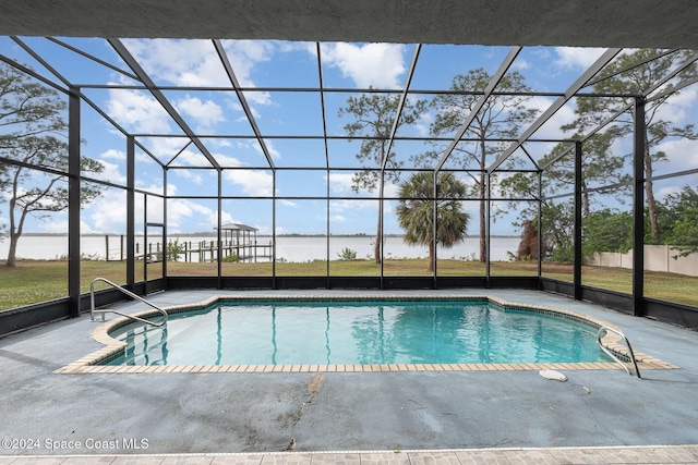 view of swimming pool with glass enclosure, a patio area, and a water view