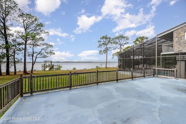 view of patio / terrace with glass enclosure and a water view