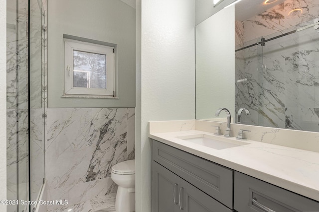 bathroom with vanity, toilet, and a shower with shower door