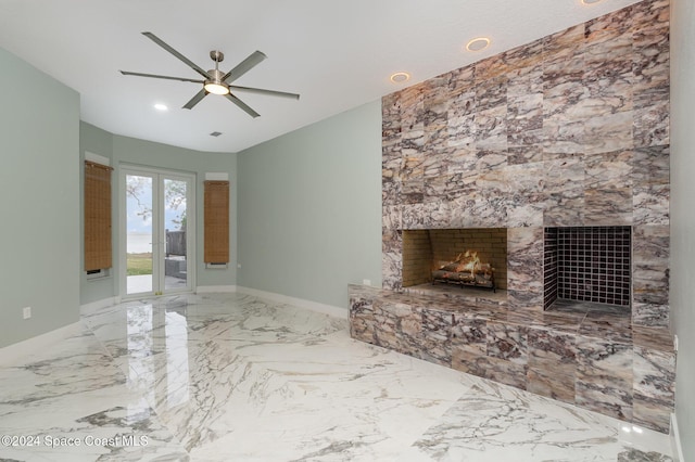 unfurnished living room featuring ceiling fan and a fireplace