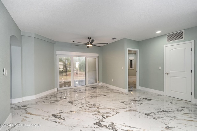 spare room featuring ceiling fan and a textured ceiling