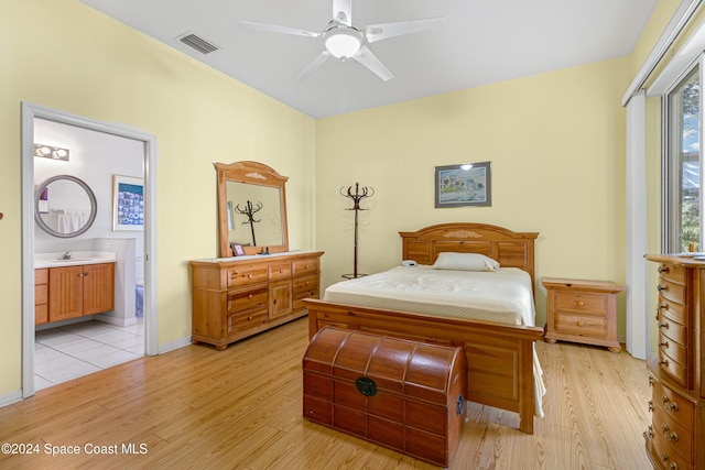 bedroom featuring ceiling fan, sink, connected bathroom, and light hardwood / wood-style flooring