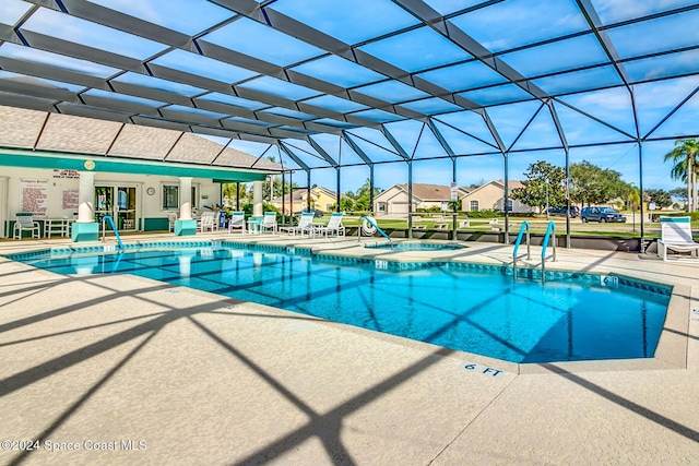 view of swimming pool with an in ground hot tub, a patio, and a lanai