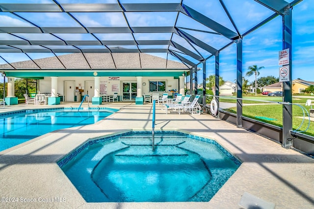 view of pool with a lanai, an in ground hot tub, and a patio