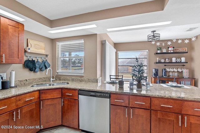 kitchen featuring light stone counters, dishwasher, light tile patterned flooring, and sink