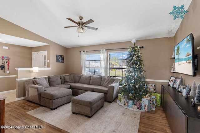 living room with wood-type flooring, vaulted ceiling, and ceiling fan