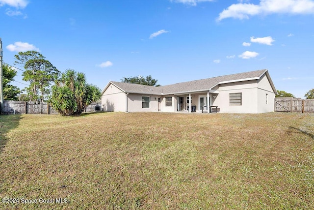 rear view of property with a lawn