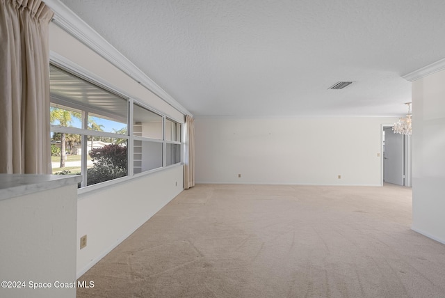 spare room with crown molding, light colored carpet, a textured ceiling, and a chandelier