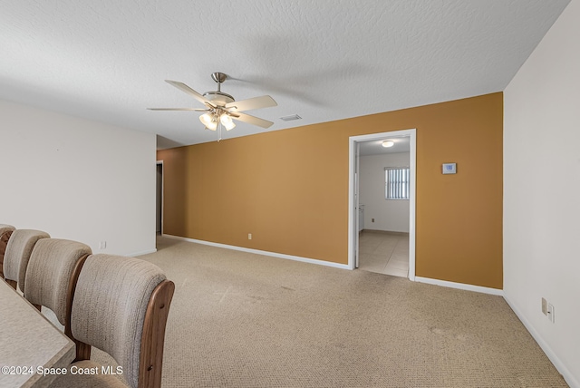 spare room with light carpet, a textured ceiling, and ceiling fan