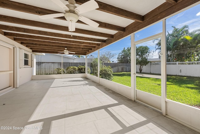 unfurnished sunroom featuring beam ceiling