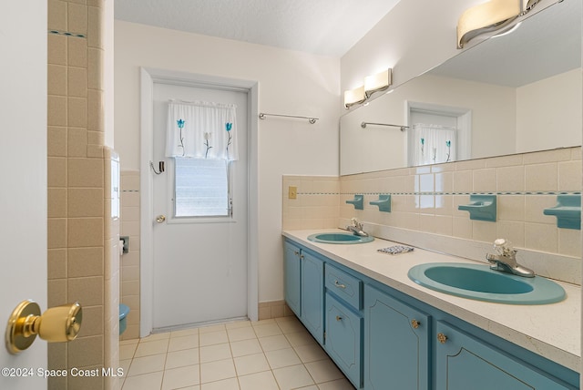 bathroom featuring tile patterned floors, vanity, tile walls, and a textured ceiling