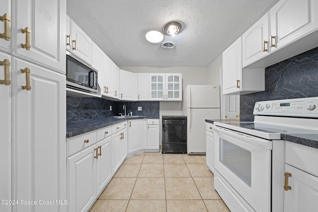 kitchen with white appliances, white cabinets, sink, light tile patterned floors, and a textured ceiling