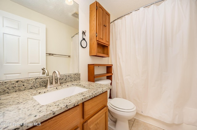 bathroom featuring tile patterned floors, vanity, a textured ceiling, and toilet