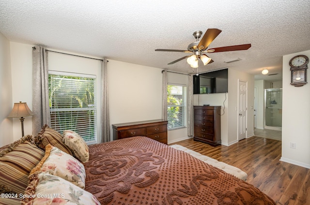 bedroom featuring ceiling fan, dark hardwood / wood-style flooring, a textured ceiling, and connected bathroom