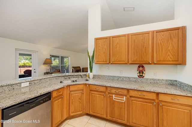 kitchen featuring dishwasher, sink, vaulted ceiling, light stone countertops, and light tile patterned floors