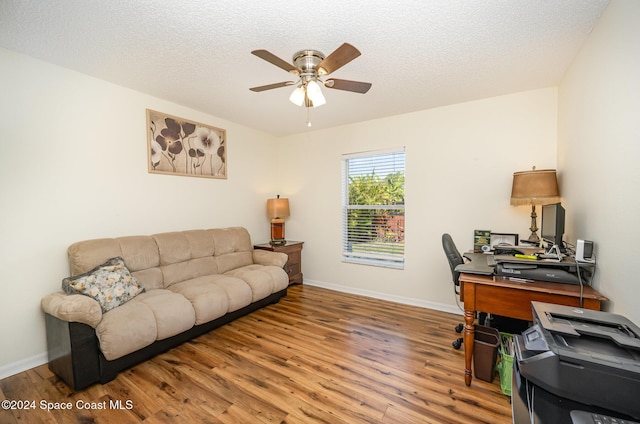 home office featuring ceiling fan, wood-type flooring, and a textured ceiling