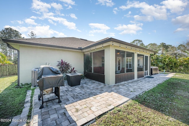 rear view of house with a yard, a patio, and a sunroom