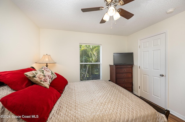 bedroom with ceiling fan, a textured ceiling, and hardwood / wood-style flooring