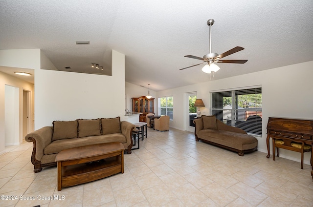 tiled living room with a textured ceiling, ceiling fan, and lofted ceiling