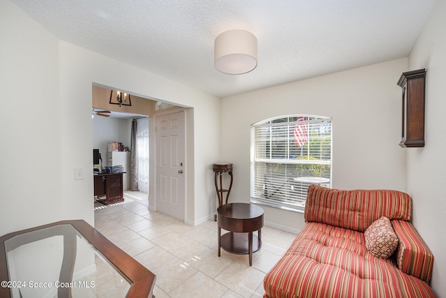 sitting room featuring light tile patterned floors, a textured ceiling, and ceiling fan