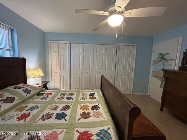 tiled bedroom with two closets and ceiling fan