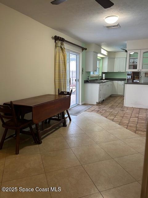 kitchen with ceiling fan, light tile patterned flooring, and white cabinetry