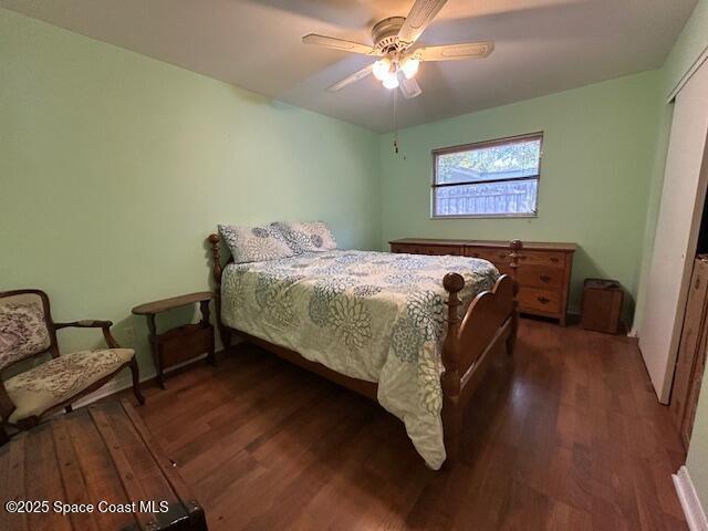 bedroom with a closet, dark hardwood / wood-style floors, and ceiling fan