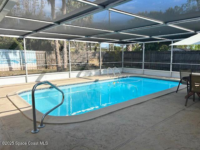 view of pool with a patio and a lanai