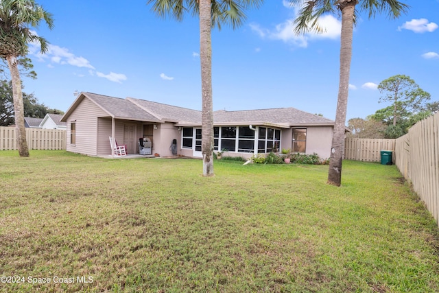 4273 Blue Lake Dr, Melbourne, FL 32901 - back of house featuring a fenced backyard, a sunroom, and stucco siding