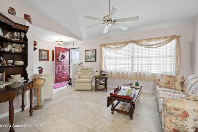 living room with ceiling fan, light tile patterned floors, and vaulted ceiling