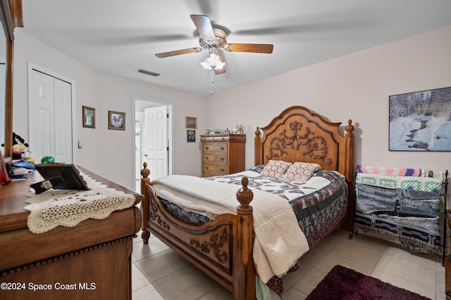 tiled bedroom featuring ceiling fan and a closet