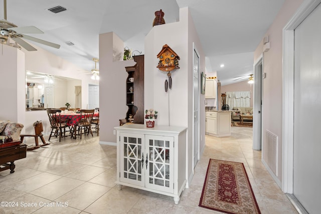 corridor featuring light tile patterned floors and vaulted ceiling