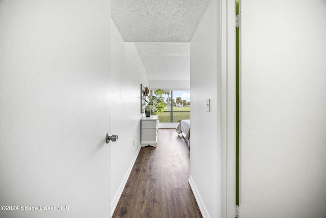 corridor featuring a textured ceiling and dark wood-type flooring