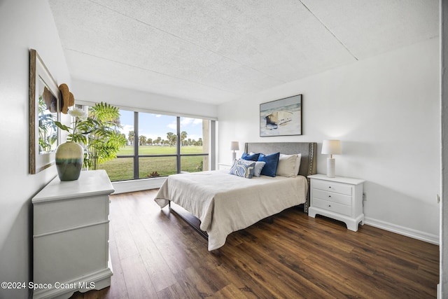 bedroom with dark hardwood / wood-style flooring and a textured ceiling