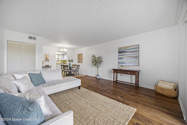 living room with a notable chandelier and dark hardwood / wood-style floors