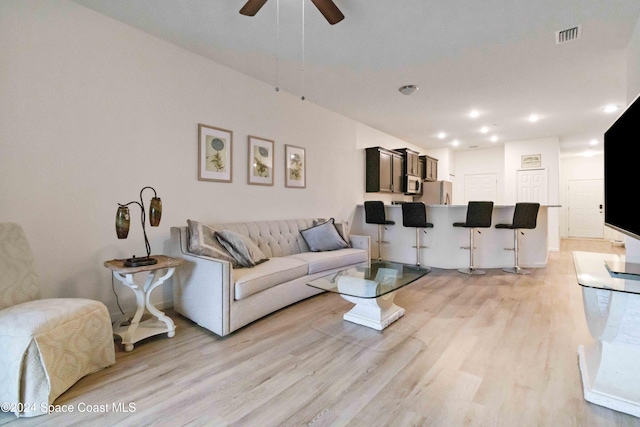 living room with light hardwood / wood-style flooring and ceiling fan