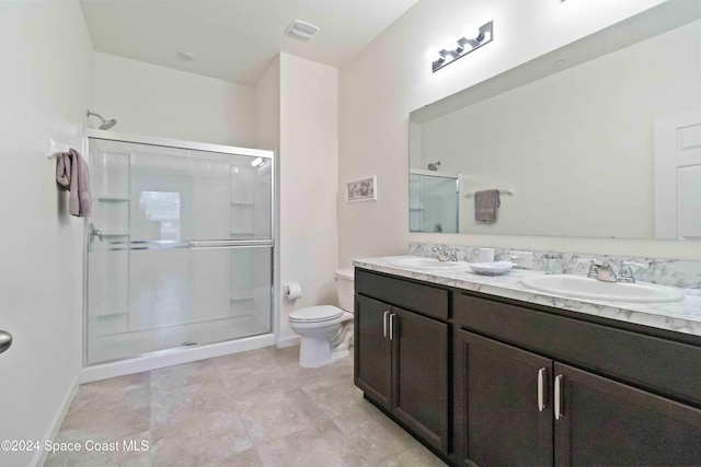 bathroom with vanity, toilet, and a shower with door