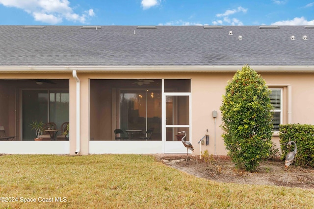 rear view of property with a sunroom and a yard