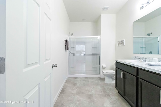 bathroom with vanity, toilet, and a shower with door