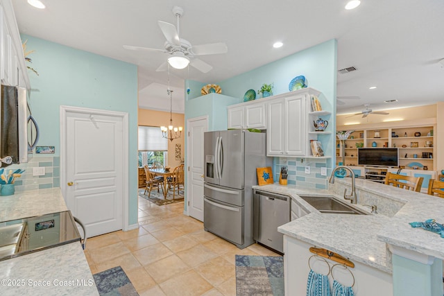 kitchen with sink, white cabinetry, stainless steel appliances, light stone counters, and tasteful backsplash