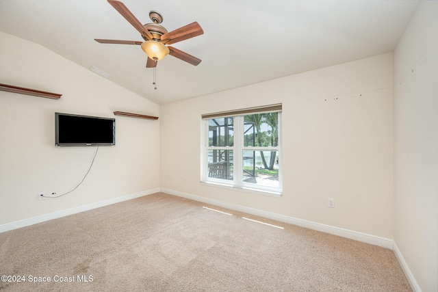 carpeted empty room featuring ceiling fan and vaulted ceiling