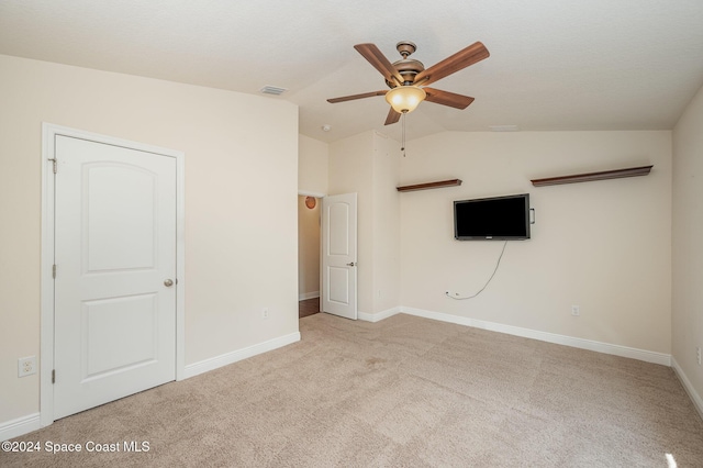 carpeted empty room featuring ceiling fan and vaulted ceiling