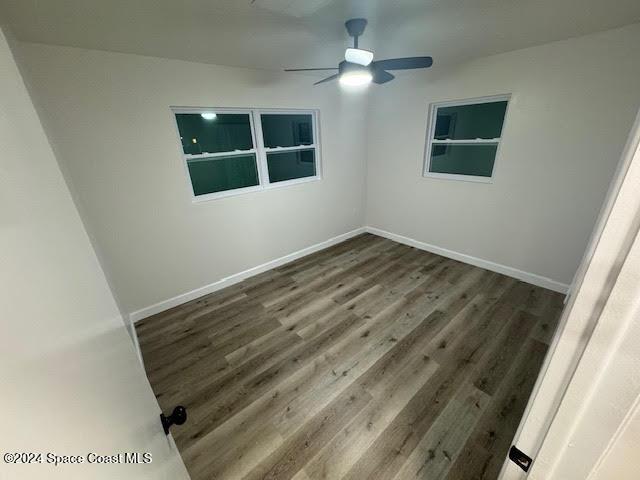 unfurnished room featuring ceiling fan and dark wood-type flooring