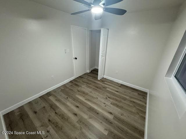 unfurnished bedroom with ceiling fan and dark hardwood / wood-style floors