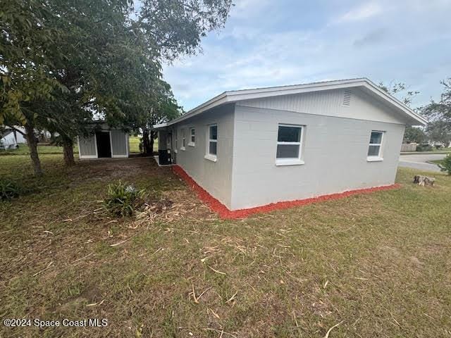 view of home's exterior with a yard and a storage shed