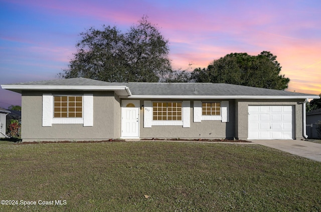 single story home featuring a yard and a garage