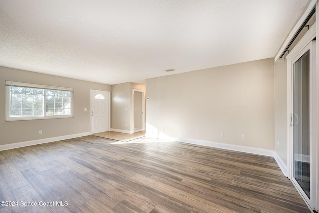 unfurnished living room featuring a textured ceiling and hardwood / wood-style flooring