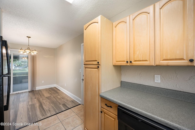 kitchen with light brown cabinetry, a textured ceiling, decorative light fixtures, and a notable chandelier