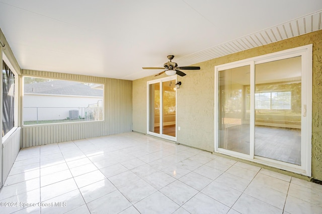 unfurnished sunroom featuring ceiling fan